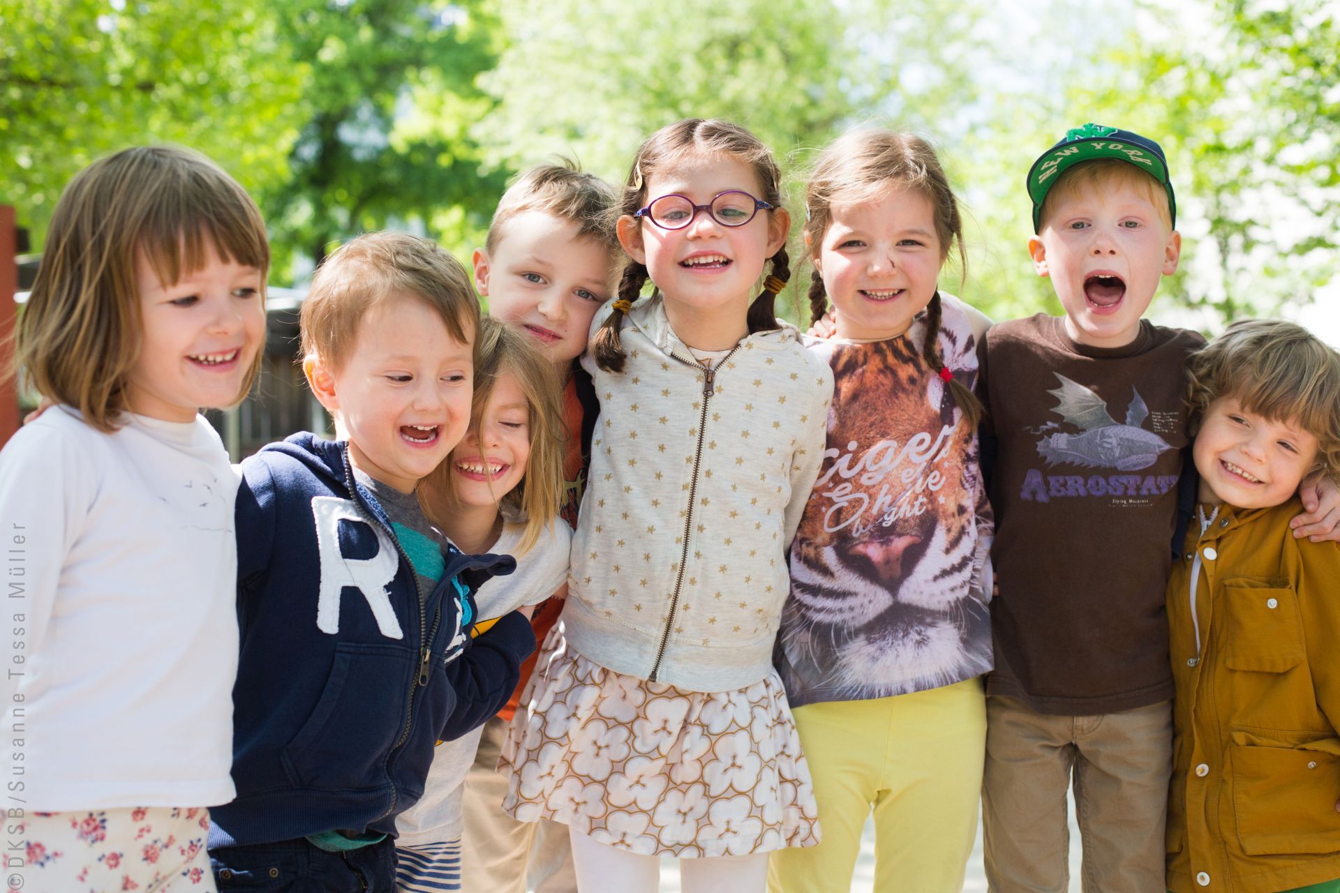 Kinder in einer Reihe umarmen sich